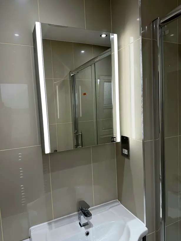 LED mirror cabinet on large gloss wall tiles