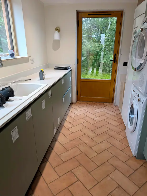 Finished utility room with terracotta herringbone floor
